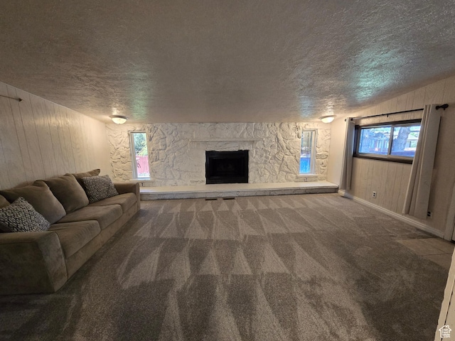 614 W Anderson Ave S, Murray, UT 84123 - carpeted living area featuring a textured ceiling, a fireplace, wooden walls, healthy amount of natural light, and vaulted ceiling
