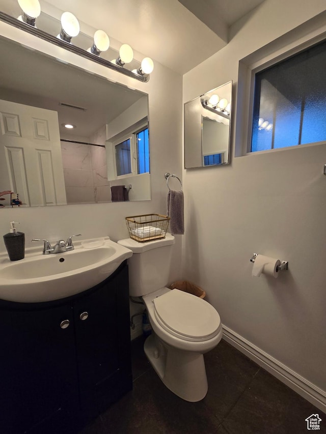 bathroom featuring toilet, tile patterned flooring, baseboards, and vanity