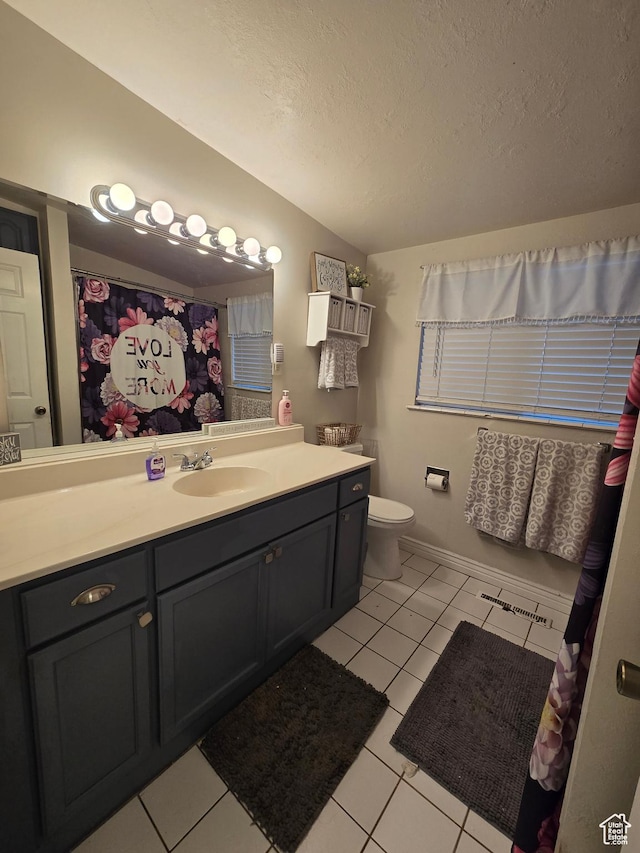bathroom featuring lofted ceiling, a textured ceiling, vanity, tile patterned flooring, and toilet