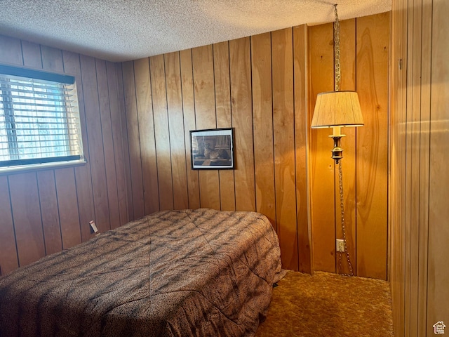 bedroom with carpet flooring, a textured ceiling, and wooden walls