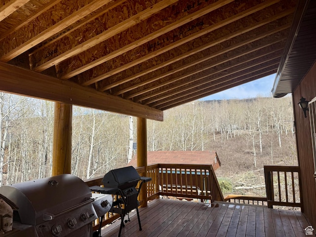 wooden deck featuring grilling area and a forest view