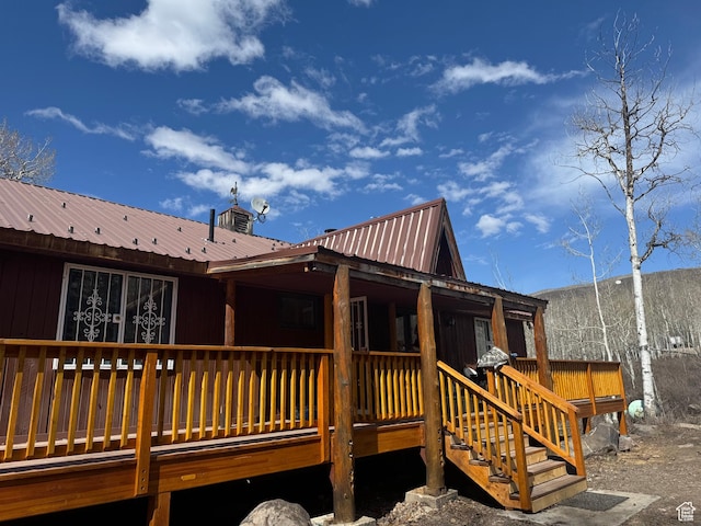 back of house with metal roof and a deck