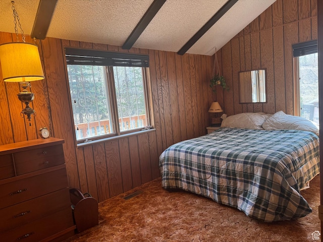 bedroom featuring carpet floors, wood walls, and a textured ceiling