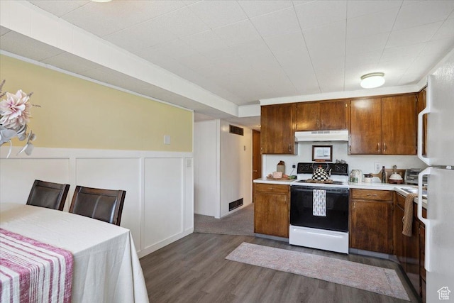 2884 N 300 E, North Ogden, UT 84414 - kitchen featuring electric range, light countertops, dark wood-style floors, brown cabinets, and a decorative wall