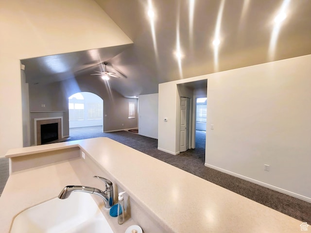 186 S 1900 W Unit R2, Lehi, UT 84043 - kitchen with dark carpet, a fireplace with raised hearth, a ceiling fan, arched walkways, and baseboards