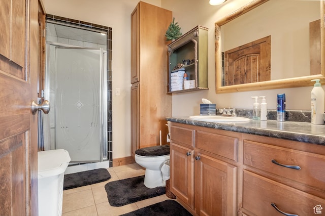 bathroom with toilet, tile patterned floors, a shower stall, and vanity