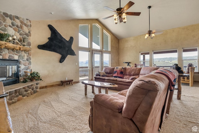 carpeted living room with high vaulted ceiling, a ceiling fan, a fireplace, and baseboards