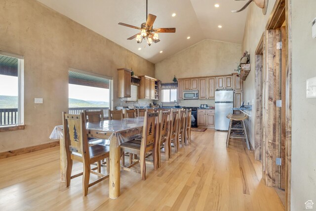 dining space featuring a ceiling fan, light wood-style flooring, high vaulted ceiling, and recessed lighting