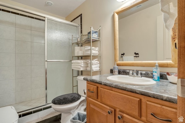 bathroom featuring toilet, a stall shower, and vanity
