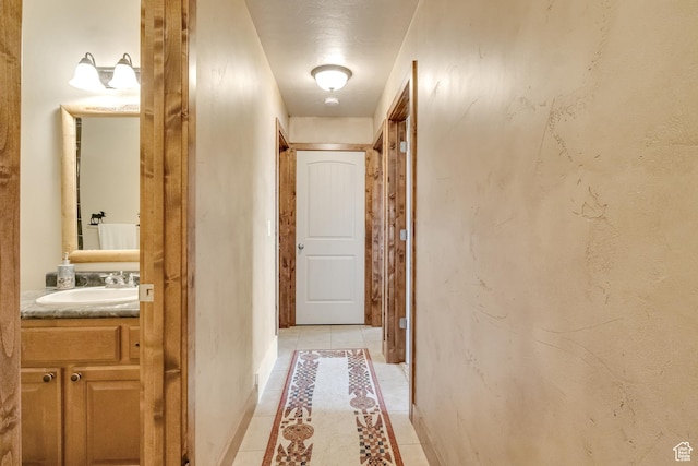 hall with a sink and light tile patterned floors