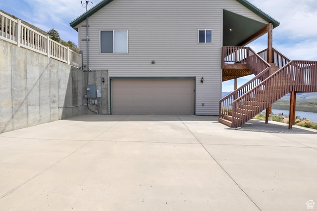 rear view of property featuring a garage and driveway