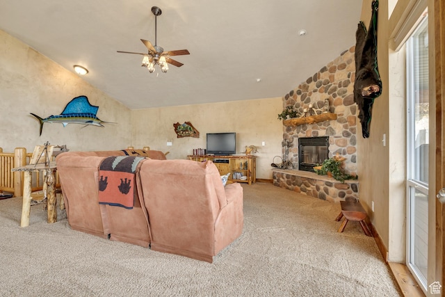 carpeted living area with ceiling fan, vaulted ceiling, and a fireplace