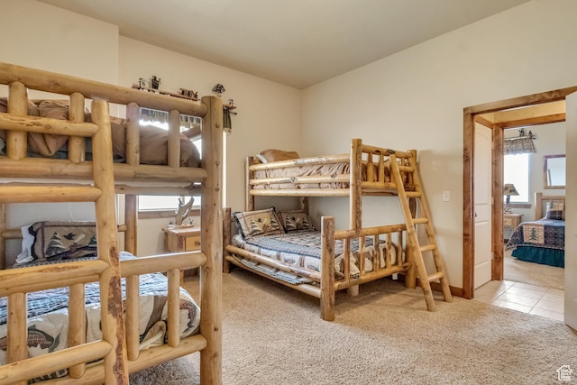 carpeted bedroom with multiple windows and tile patterned floors