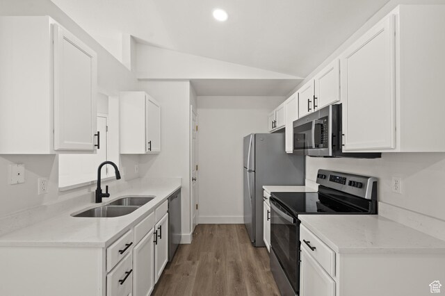 3860 S Mccall St E Unit 3C, Salt Lake City, UT 84115 - kitchen with stainless steel appliances, a sink, lofted ceiling, white cabinets, and wood finished floors