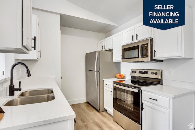 3860 S Mccall St E Unit 3C, Salt Lake City, UT 84115 - kitchen featuring stainless steel appliances, a sink, lofted ceiling, white cabinetry, and light wood finished floors