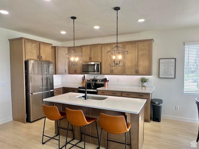 kitchen featuring stainless steel appliances, a sink, tasteful backsplash, baseboards, and recessed lighting
