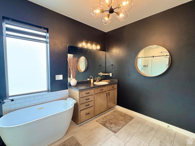 full bath with a chandelier, a soaking tub, tile patterned flooring, and vanity