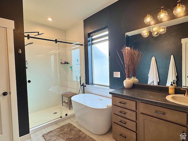 bathroom with a shower stall, a soaking tub, vanity, and tile patterned floors