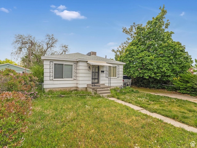 bungalow-style house featuring a front lawn