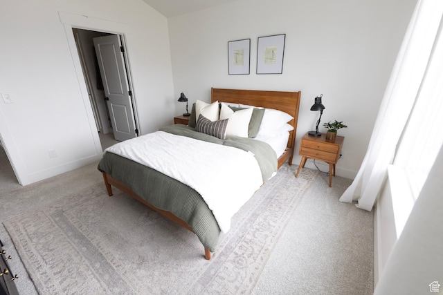 bedroom with light carpet and baseboards