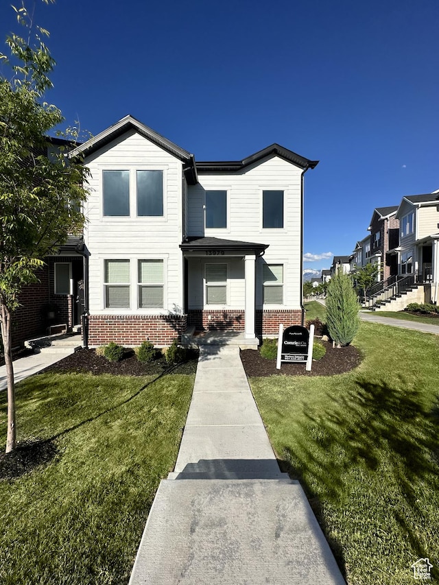 traditional-style house featuring brick siding and a front yard