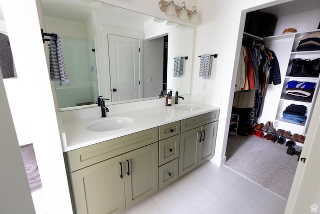 bathroom with a walk in closet, double vanity, and a shower