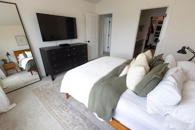 bedroom with light colored carpet, a spacious closet, and a closet