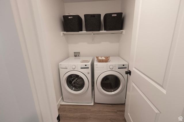 clothes washing area with washer and clothes dryer and wood finished floors