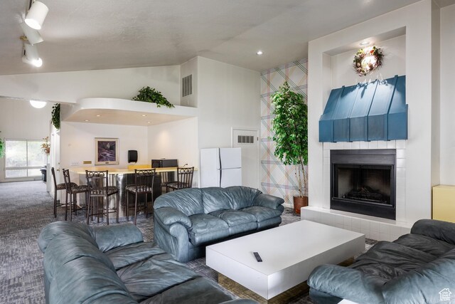 1443 W Spinnaker Row S, Taylorsville, UT 84123 - living room featuring a tile fireplace, carpet floors, and vaulted ceiling