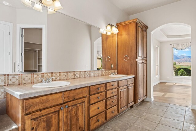 full bathroom featuring decorative backsplash, tile patterned floors, and double vanity