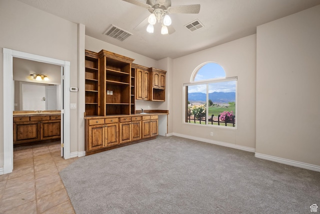 unfurnished living room featuring a ceiling fan and baseboards