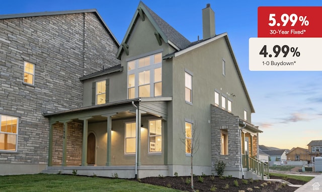11419 S Watercourse Rd Unit 188, South Jordan, UT 84009 - back of property at dusk with stone siding, stucco siding, and covered porch