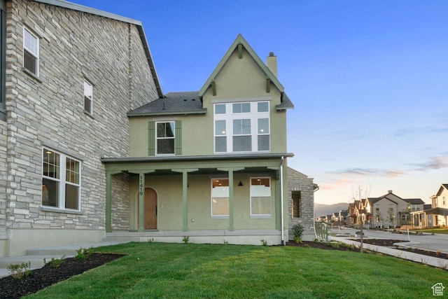11419 S Watercourse Rd Unit 188, South Jordan, UT 84009 - back of property at dusk with stucco siding, stone siding, a lawn, a chimney, and a porch