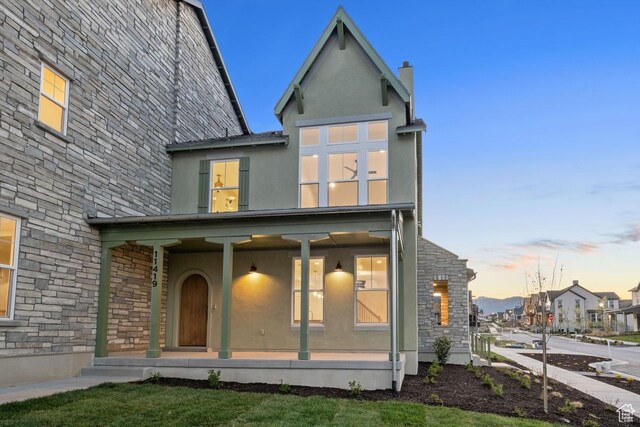 11419 S Watercourse Rd Unit 188, South Jordan, UT 84009 - rear view of house featuring covered porch, stone siding, and stucco siding