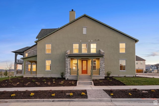 11419 S Watercourse Rd Unit 188, South Jordan, UT 84009 - view of front of house featuring a porch, stucco siding, a chimney, and stone siding