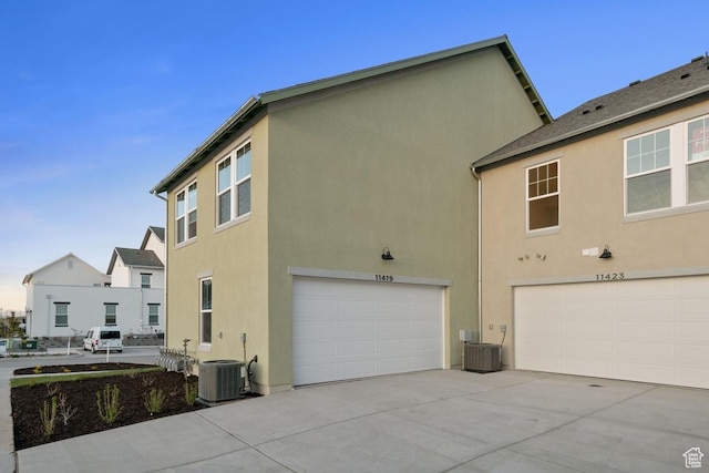 11419 S Watercourse Rd Unit 188, South Jordan, UT 84009 - view of property exterior featuring an attached garage, stucco siding, central air condition unit, and concrete driveway