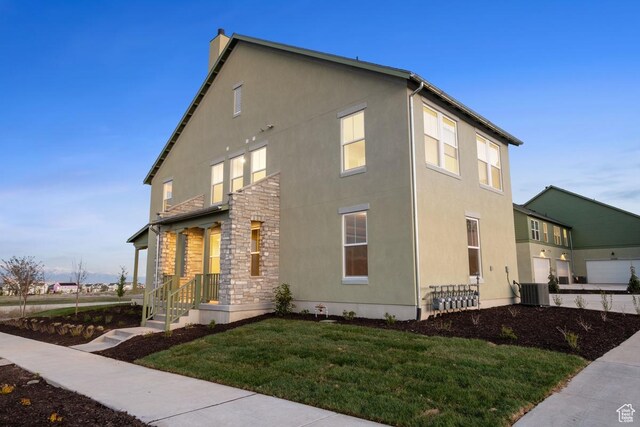11419 S Watercourse Rd Unit 188, South Jordan, UT 84009 - view of home's exterior featuring stucco siding, a lawn, a chimney, and central air condition unit
