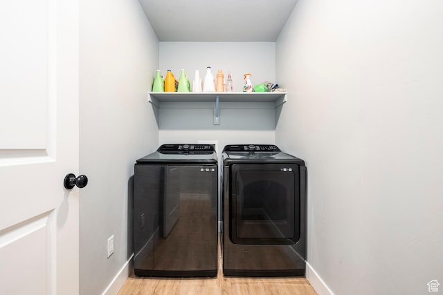 laundry room featuring washer and clothes dryer, light wood-type flooring, and baseboards