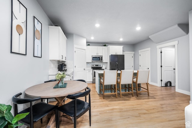 dining area featuring recessed lighting, light wood-type flooring, and baseboards