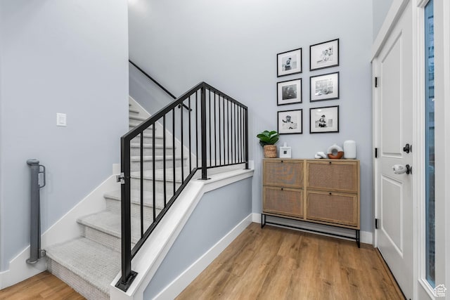 stairs with wood finished floors and baseboards