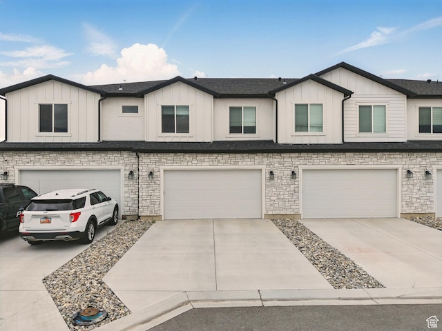 multi unit property featuring an attached garage, board and batten siding, and concrete driveway