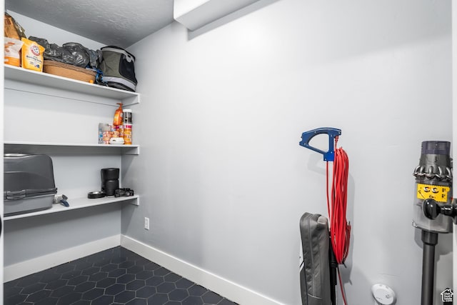 home office with baseboards and dark tile patterned flooring