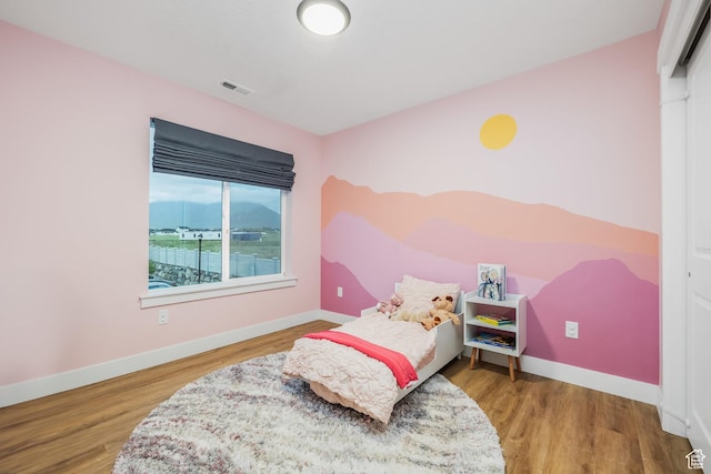 bedroom featuring baseboards and wood finished floors