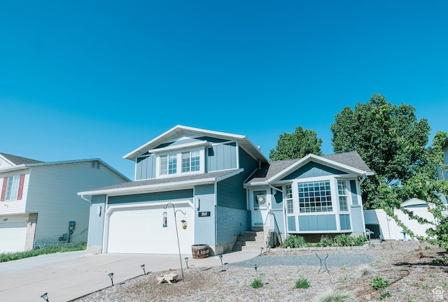 view of front facade featuring board and batten siding, concrete driveway, a garage, fence, and brick siding