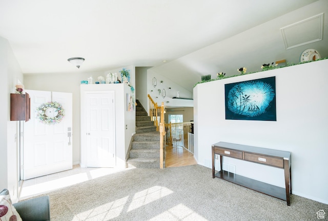 entryway featuring vaulted ceiling, carpet floors, stairs, and baseboards
