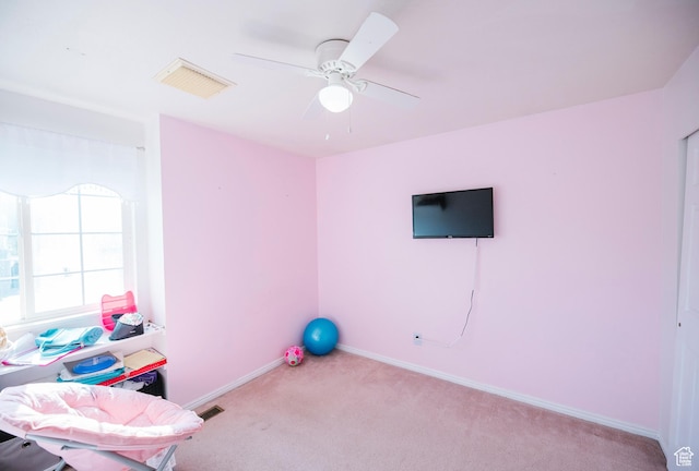 exercise room featuring carpet, baseboards, and a ceiling fan