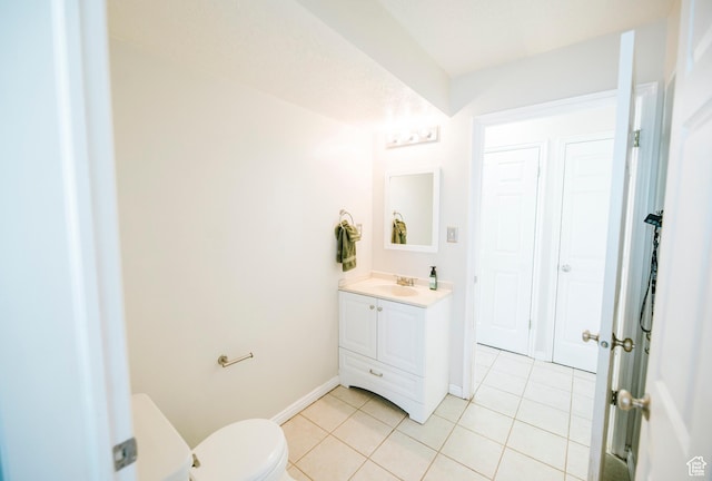 bathroom with tile patterned floors, vanity, baseboards, and toilet