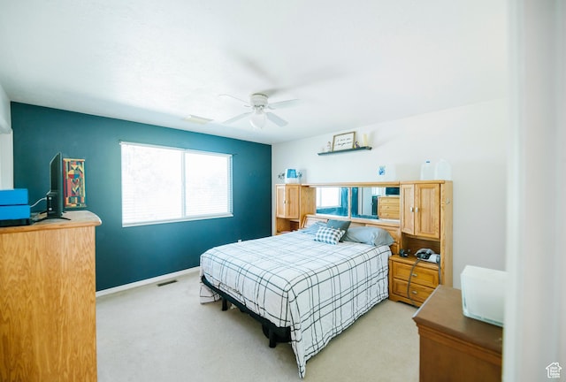 bedroom featuring light carpet, baseboards, and ceiling fan