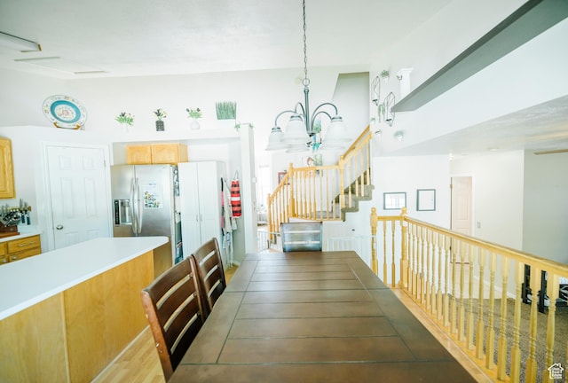 dining area featuring a chandelier, stairway, and wood finished floors