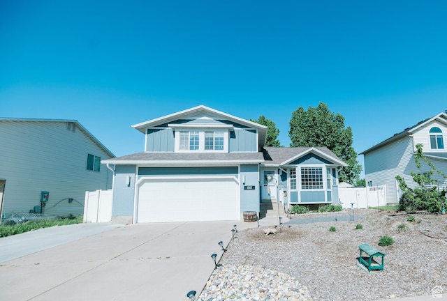 view of front of house featuring concrete driveway, fence, a garage, and board and batten siding